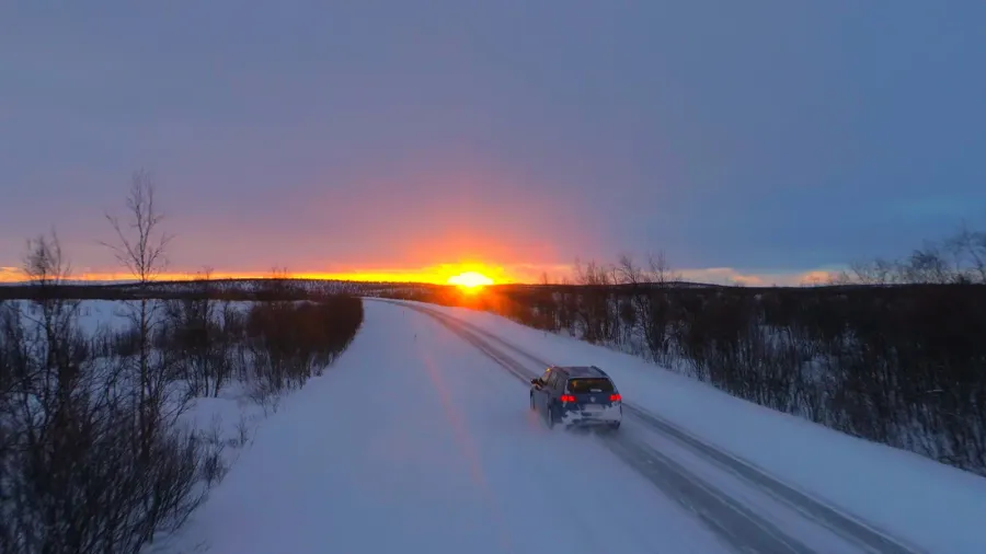 aerial lens flare flying behind tourist car speeding through the