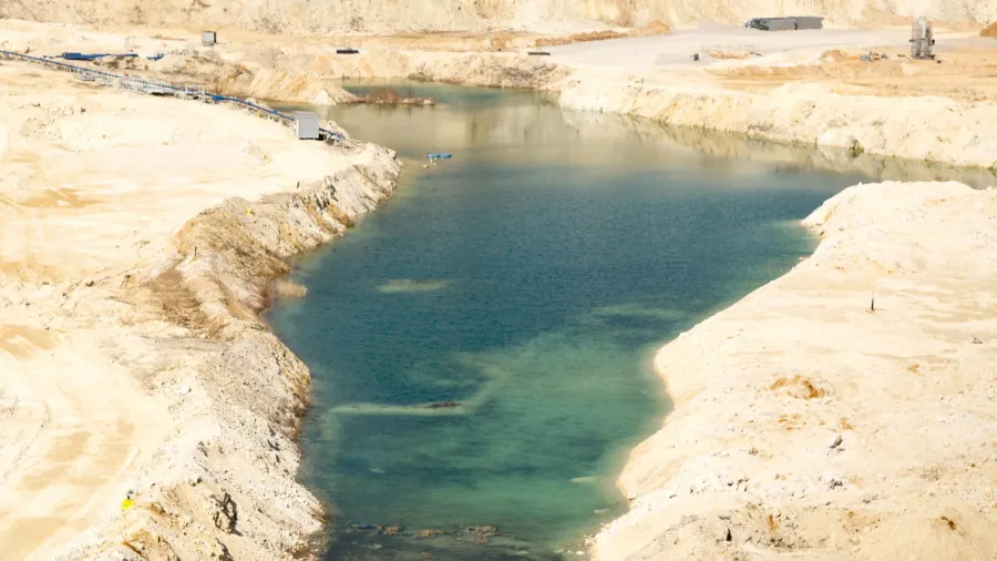 aerial view of an opencast sand gravel mine with pond