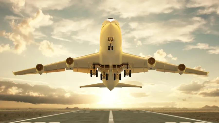 airplane taking off at sunset