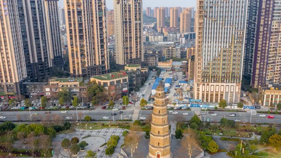 an ancient pagoda stands tall amidst modern high rise buildings