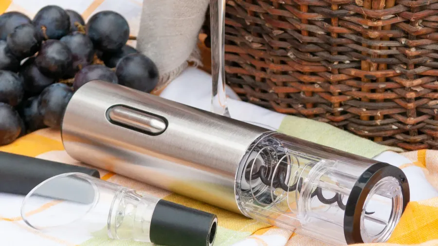 An electric wine opener placed near berries.