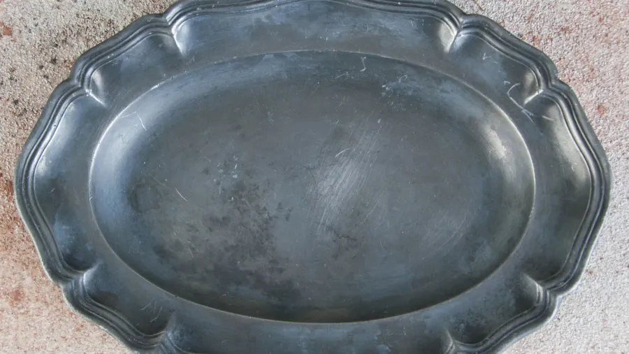 antique pewter oval plate on concrete background