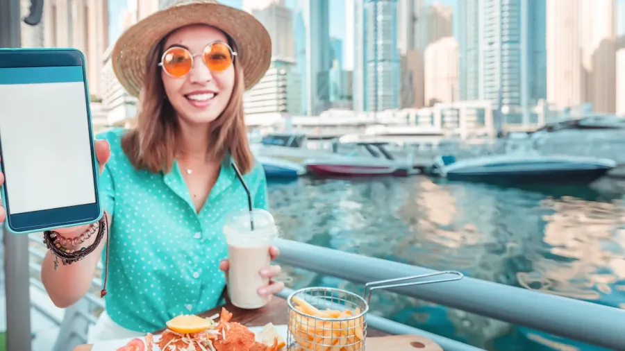 asian girl eats seafood cuisine overlooking the skyscrapers and marina