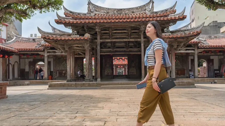 asian tourist walking in the temple looking for somewhere to
