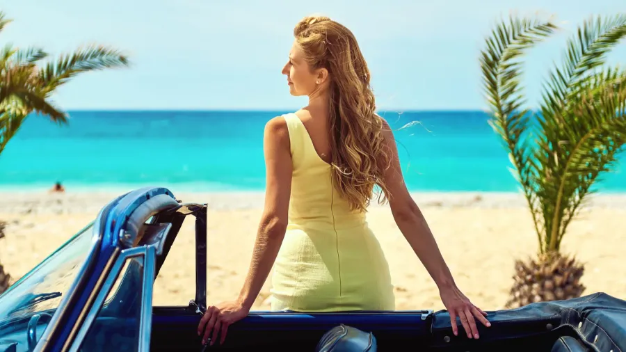 attractive woman near retro car on the tropical beach