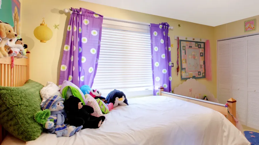 baby girl room with toys and purple curtains