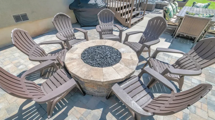 backyard patio of a home with wooden chairs around a