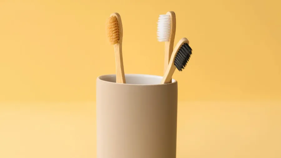 bamboo tooth brushes in holder on beige background