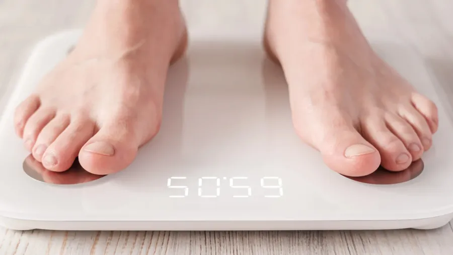 bare feet stand on smart scales that makes bioelectric impedance