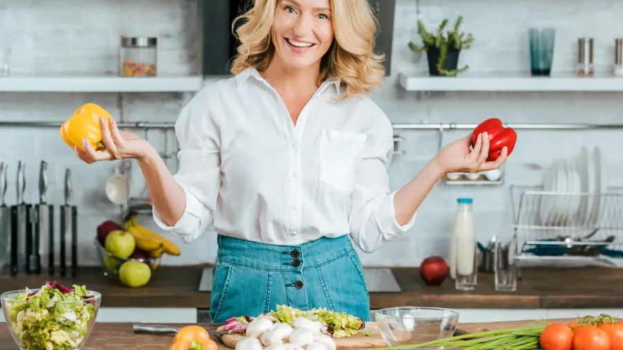 beautiful adult woman with bell peppers looking at camera while