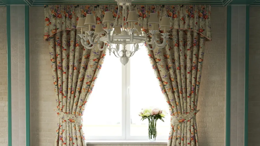 Colorful floral curtains on a window with a white chandelier in front of it.