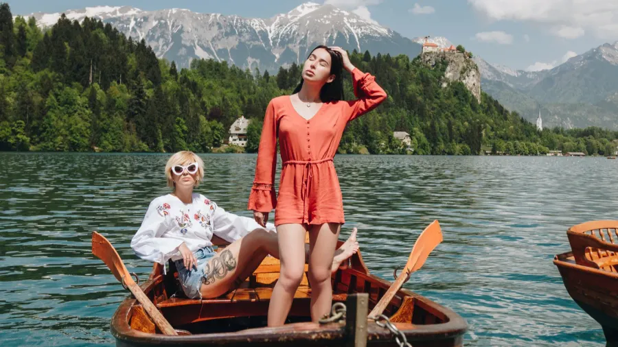 beautiful young women in boat at tranquil mountain lake bled