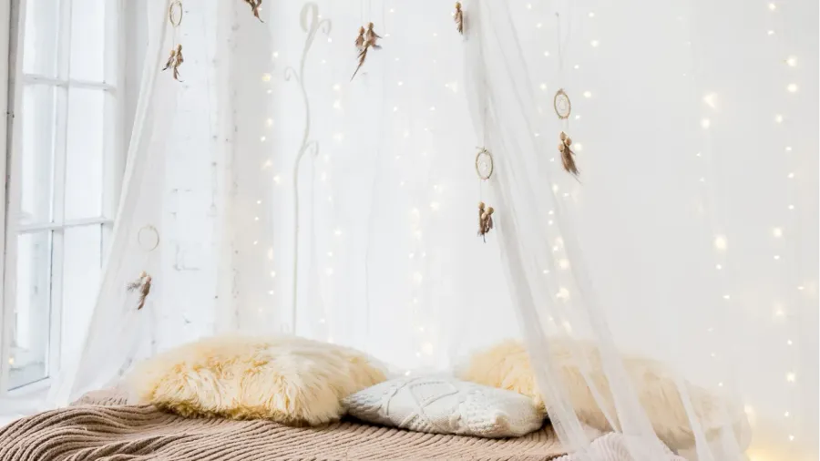 bed with patterned bedding and white drapes in bright bedroom