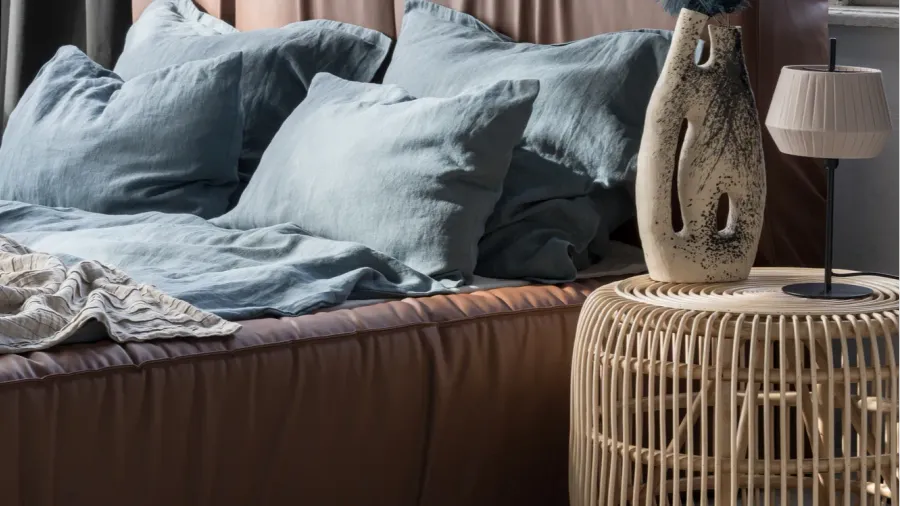 big and comfortable bed with leather headboard and blue flax