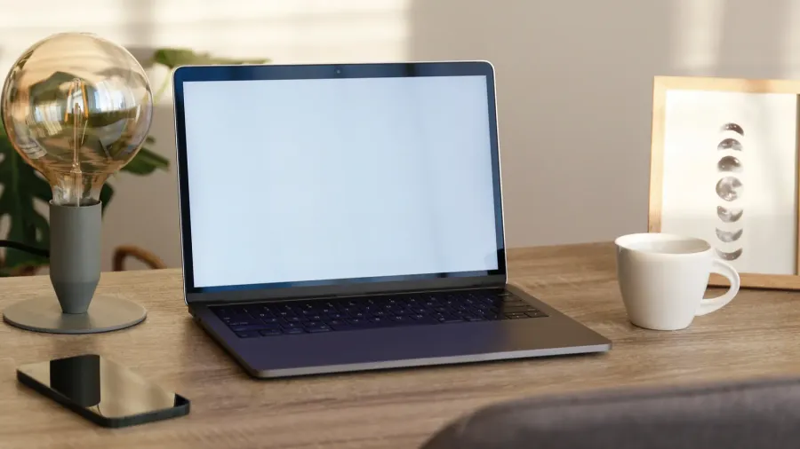 blank screen laptop cell phone and a cup on wooden