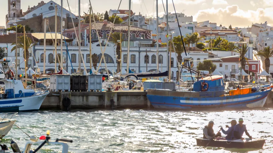boats in marina of lagos with the old town behind