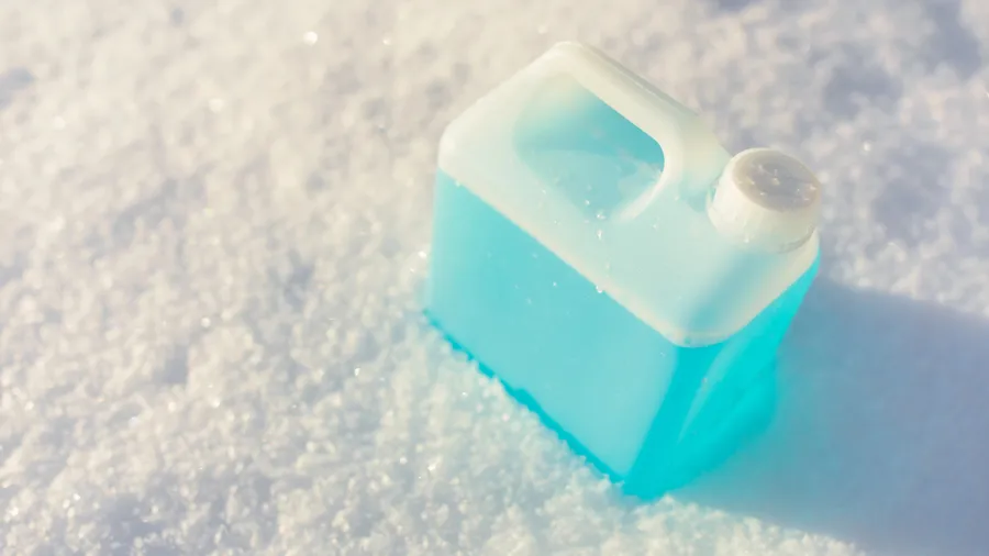 bottle with non-freezing windshield washer fluid, snow background