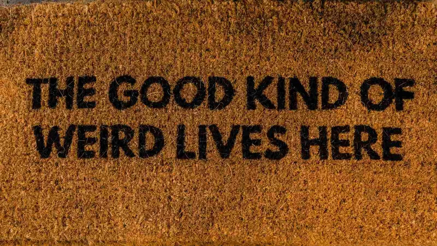 A brown and black door mat with a fun quote on it.