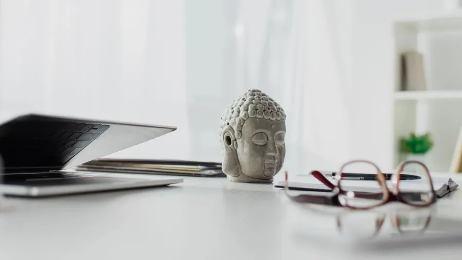 buddha head eyeglasses and laptop on table in modern office