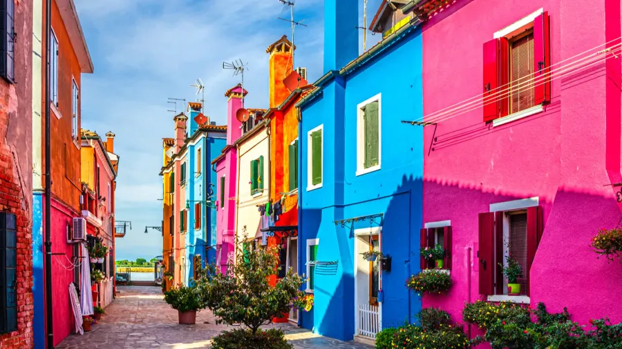 burano island narrow cobblestone street between colorful houses buildings with
