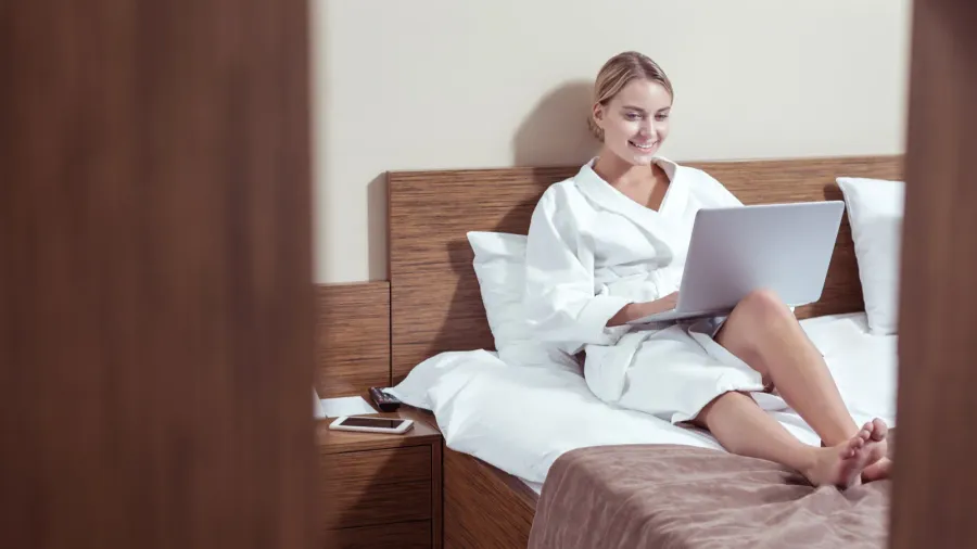 busy businesswoman lying in hotel room feeling busy working on
