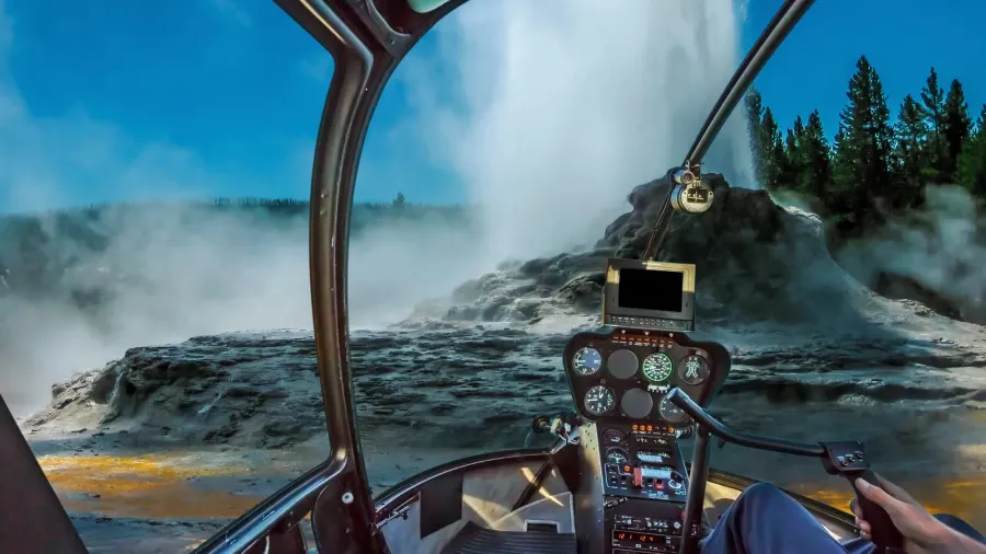 Helicopter cockpit flight over Castle Geyser with hot water and steam pools of thermophilic bacteria and cone geyser in Upper Geyser Basin of Yellowstone National Park, Wyoming,