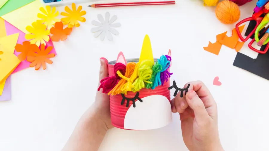 child makes a handmade unicorn out of a tin can