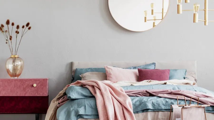 classy round mirror on grey wall in stylish bedroom interior