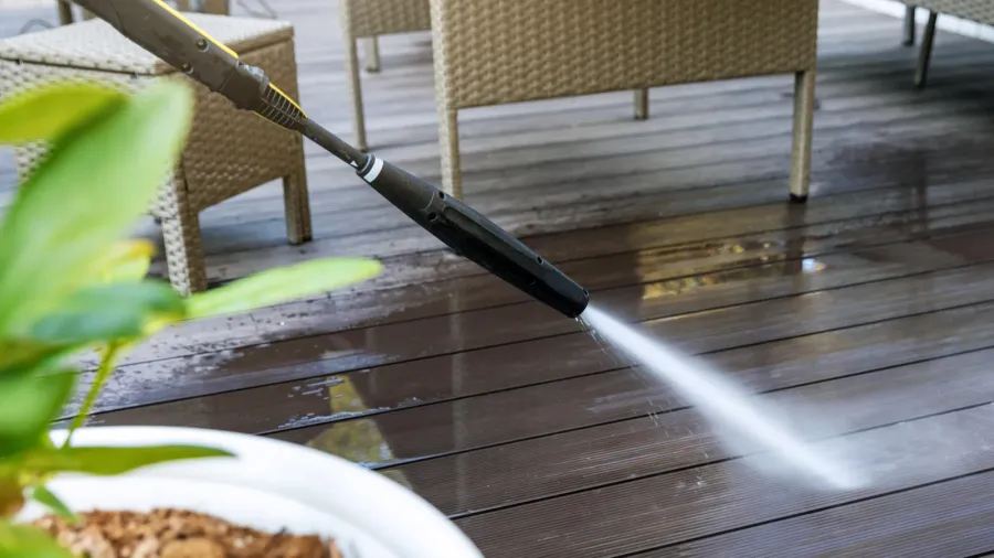 cleaning wooden terrace planks with high pressure washer
