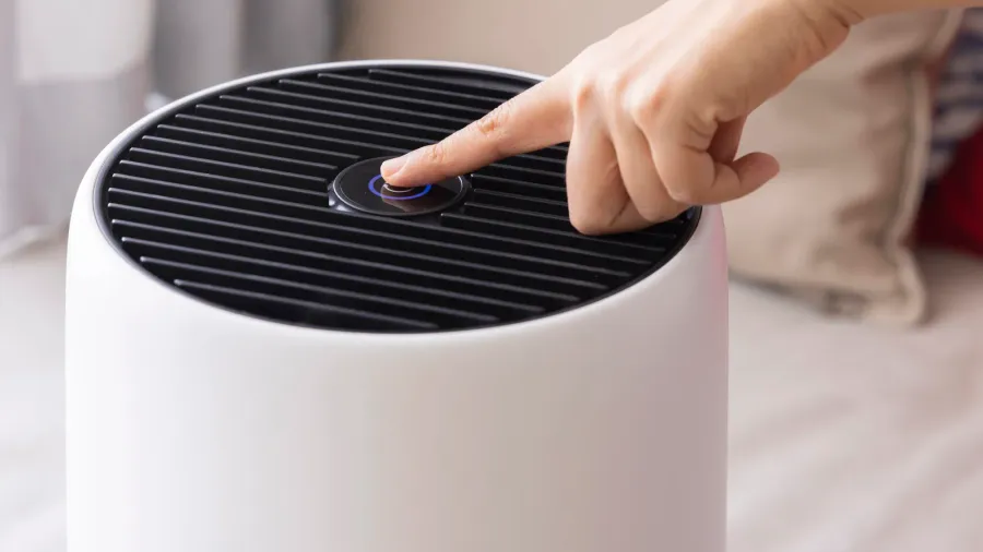 closeup asian woman hand pressing a button on air purifier