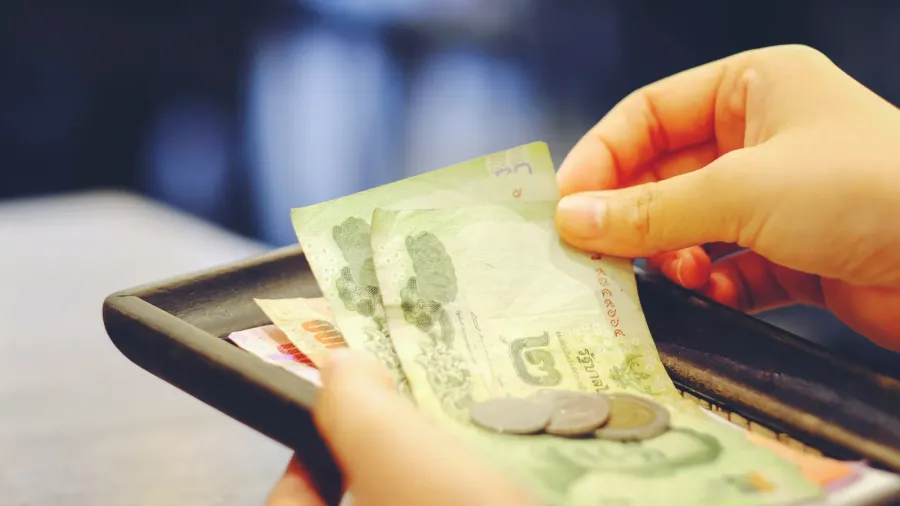 closeup hand holding of bill with thai money banknote and