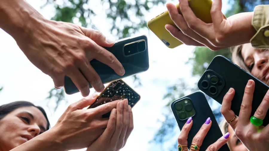 closeup of a diverse group using smartphones to capture or
