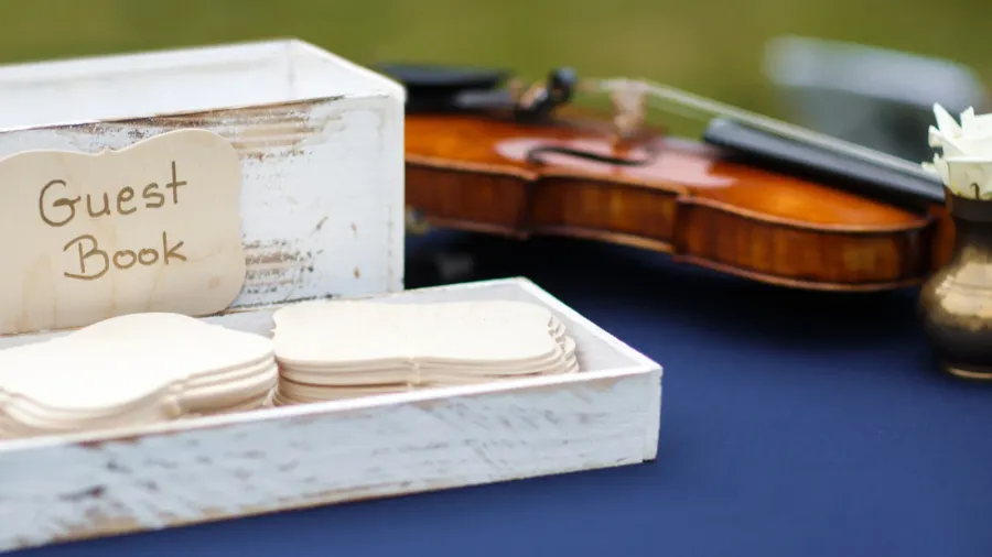 close up of wedding guest book and violin on the
