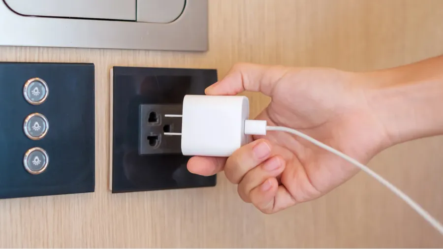 closeup finger unplugging or plugging of electricity device at home