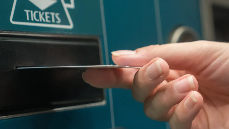 closeup hand with train ticket from self service machine