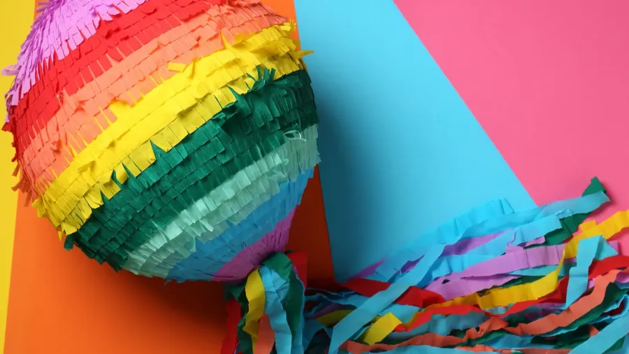 colorful pinata on color background top view