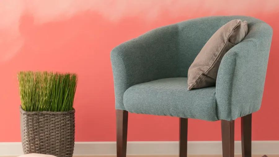 comfortable armchair near pink wall