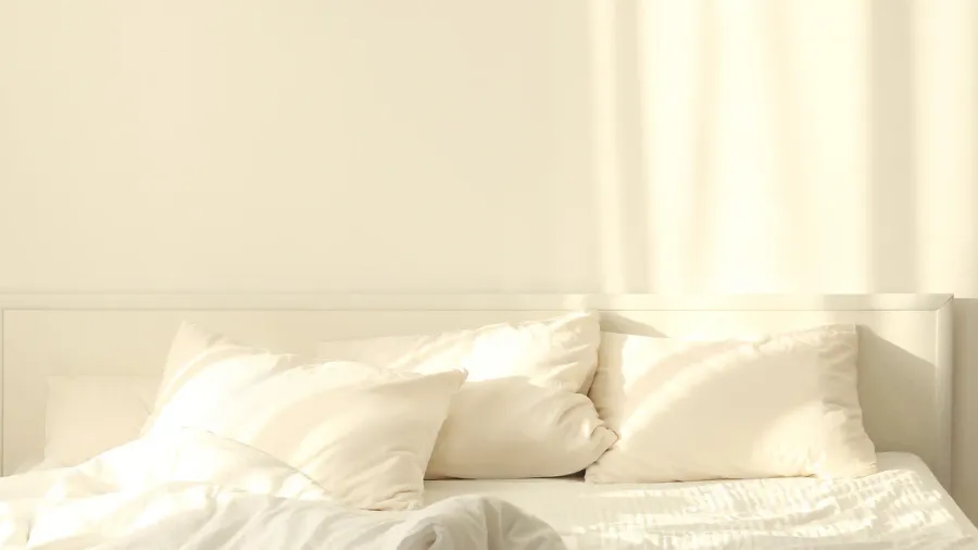 A bed with comfortable pillows and blanket.