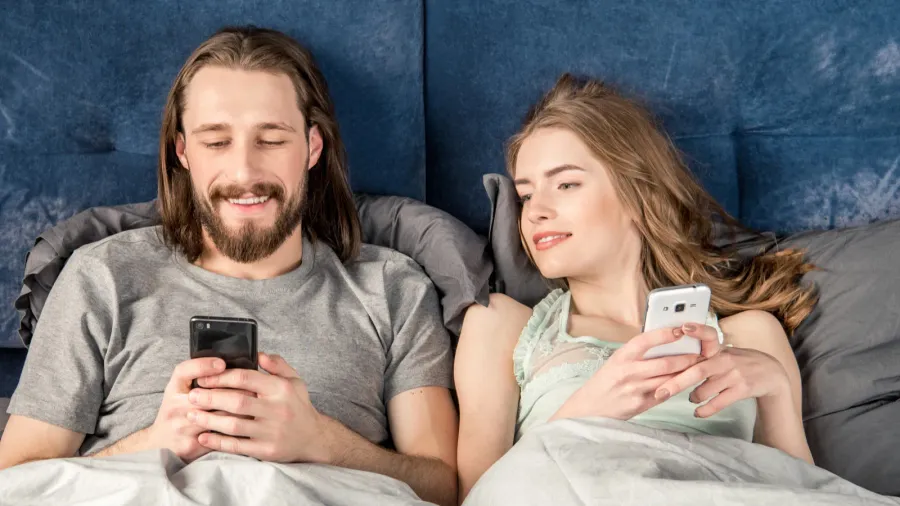 couple in bed with smartphones