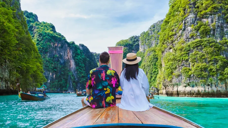 couple of men and women in front of longtail boat