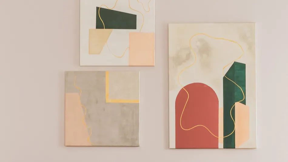 A set of three abstract art pieces in soft colors adorns a wall, adding a contemporary touch to the decor.