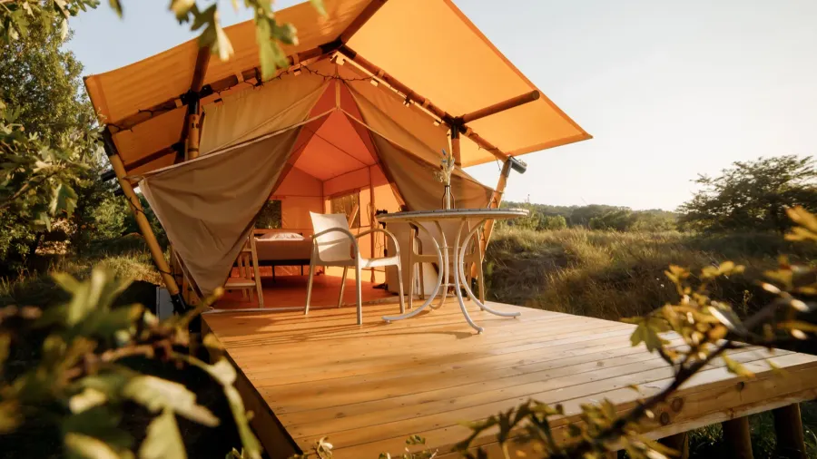 cozy open glamping tent with light inside during sunset luxury