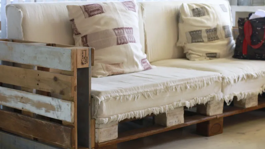 A wooden pallet sofa in living room with throw pillows.