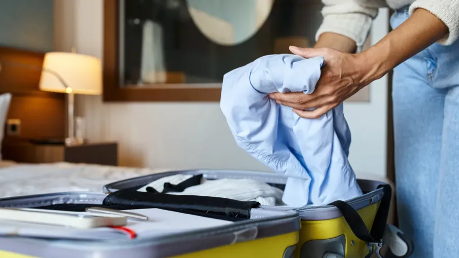 cropped view of african american woman packing her blue shirt