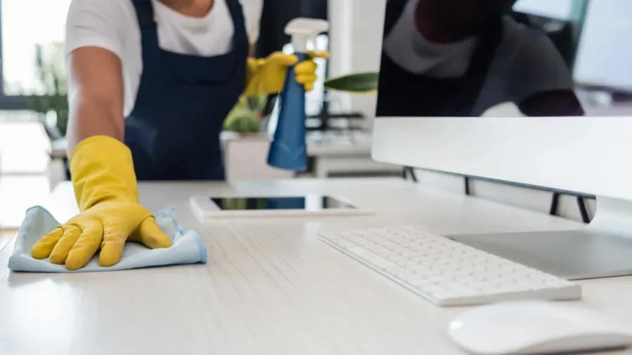 cropped view of biracial woman in rubber gloves cleaning office