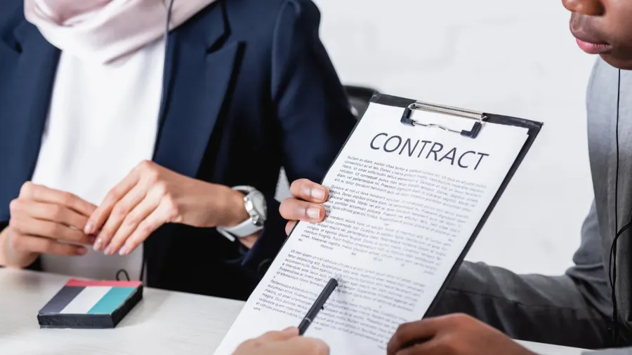 cropped view of interpreter pointing with pen at contract near