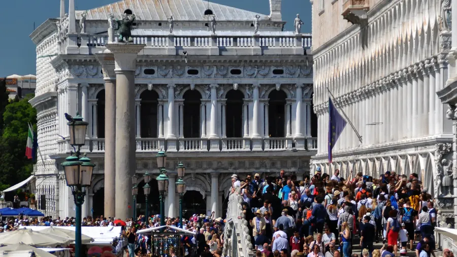 crowd of tourists on a sunny day near the piazza