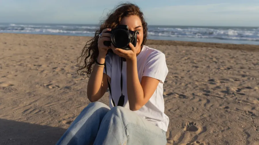 curly woman sitting in blue jeans and white tshirt taking