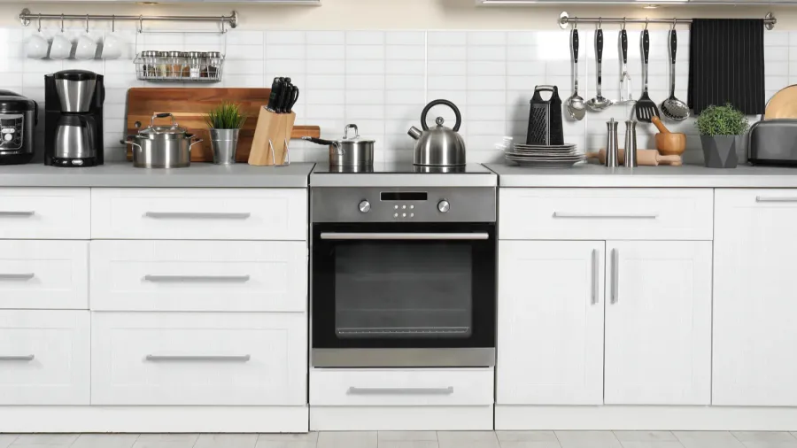 different appliances clean dishes and utensils on kitchen counter