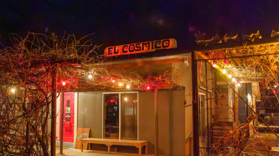 el cosmico front door entrance and sign at night in